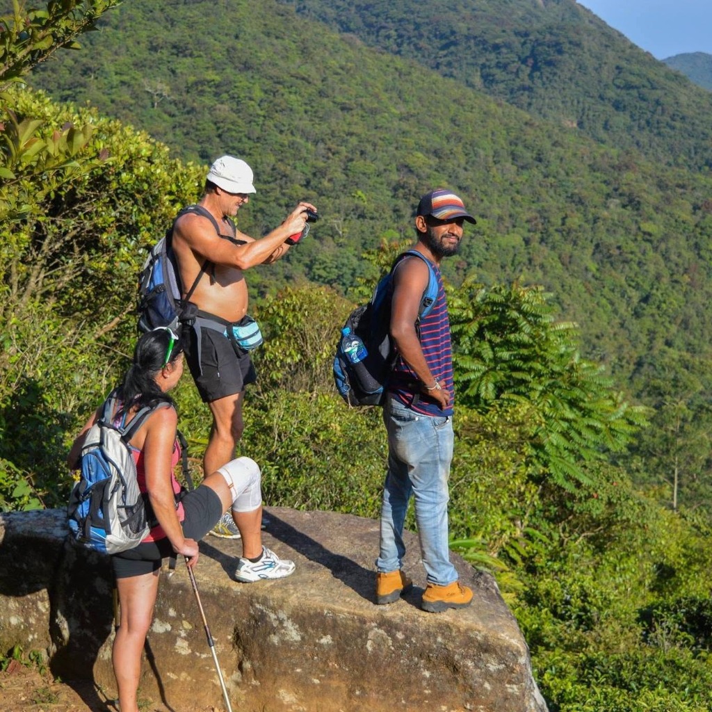 Hikers and guide enjoying panoramic mountain views and taking photos in the Knuckles Range